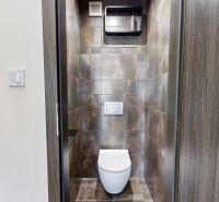Toaleta s tmavými obklady ve 4-pokojovém bytě, elegantní design místnosti.