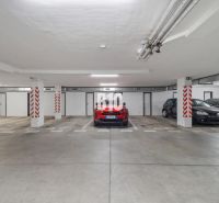 Podzemní garáž se zaparkovanými auty ve 4-pokojovém bytě v Nitře, betonová podlaha.