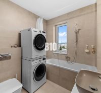 Koupelna se sprchou, pračkou a sušičkou ve 4pokojovém bytě, jednoduchý design.