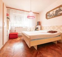 Ložnice v rodinném domě s podlahou s dřevěným dekorem a vintage doplňky.