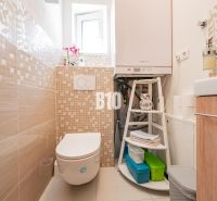 Koupelna v rodinném domě s kachličkami a moderním vybavením.