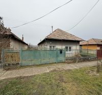 Rodinný dům v Sikenici se starším plotem a zahradou, obklopený dalšími domy.