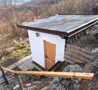 Malá chata se šikmou střechou v Dolních Orešanech na kopcovité ulici Dolní Orešany.