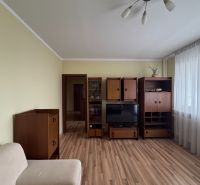 Obývací pokoj v 3-pokojovém bytě s nábytkem a podlahou s dřevěným dekorem.