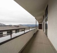 Balkón Rekreačního apartmánu v Donovalech nabízí výhled na okolní hory i střechy budov.