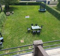 Zahrada u chaty v Kaluži s trampolínou a posezením na trávě.