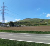 Krajina na Továrenské v Smolenicích se zemědělskými a lesními pozemky a elektrickým vedením.