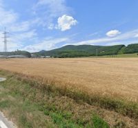 Zemědělské a lesní pozemky na Tovární ulici ve Smolenicích s výhledem na kopce.
