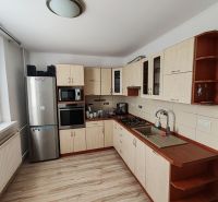 Kuchyně v 3-pokojovém bytě s podlahou s dřevěným dekorem a spotřebiči.