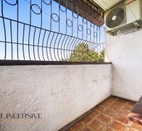 Balkon s kovovým zábradlím a klimatizací ve 3pokojovém bytě s výhledem na zeleň.