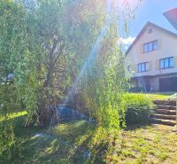 Zahrada u rodinného domu na ulici Na Vrších v Sázavě s okrasnými keři a schody.