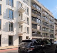 Ulice Banskobystrická, Bratislava - Staré Město, zobrazuje moderní fasádu budov a zaparkovaná auta.