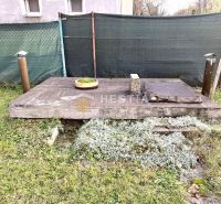 Zahradní prvek u rodinného domu v Senici s dřevěným dekorem a vegetací.