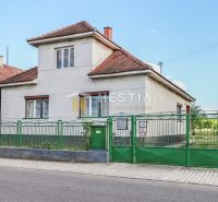 Rodinný dům v Borském Mikuláši s bílými stěnami a zeleným plotem.