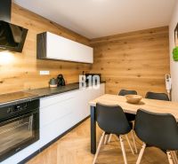 Kuchyně v rekreačním apartmánu s podlahou s dřevěným dekorem a stylovým nábytkem.