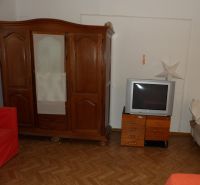 Pokoj v 2-pokojovém bytě s dřevěným nábytkem a podlahou s dřevěným dekorem.