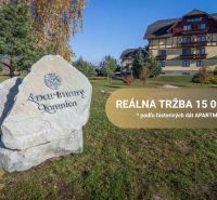 Velká Lomnica: Apartmány, zeleň, budovy v pozadí, nápis na skále.
