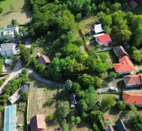 Letecký pohled na malebné Zahrady v Kolačně s roztroušenými domy a zelení.