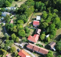 Pohled shora na zelené zahrady v obci Kolačno s okolím domů.