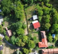Letecký pohled na zahrady a domy v Kolačne, obklopené hustou zelení.