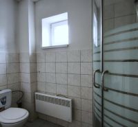 Koupelna s toaletou a sprchovým koutem ve výrobních prostorách.