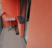 Balkon s červenými stěnami ve 2-pokojovém bytě na Nábrežní ulici ve Vrútkách.