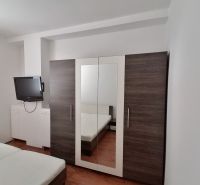 Ložnice s televizí, šatní skříní a postelí, 2pokojový byt.