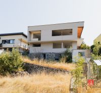 Rodinný dům na Komenského ulici v Banské Bystrici se zanedbanou zahradou a skleníkem.