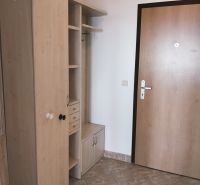 Vstupní chodba se skříňkami a věšákovou stěnou v 2-pokojovém bytě.