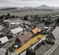 Letecký pohled na rodinné domy v Žabokrekách obklopené poli a horami.