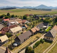 Žabokreky: Panorama rodinných domů s venkovským charakterem a kopci v pozadí.