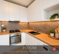 Kuchyně ve 3-pokojovém bytě se stolem, bílými skříňkami a pohodlným prostorem na vaření.