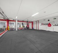 Fitness prostor s boxovacím pytlem a zrcadly.