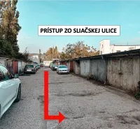 Garáže v Bratislavě - Novém Městě na Sliačské ulici, lemované zaparkovanými auty.