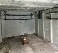 Betonová místnost s držáky na stěně a podlahou s dřevěným dekorem v garážích.