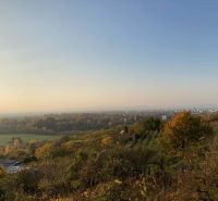 Panoráma podzimního lesa a polí s výhledem na město Banka.