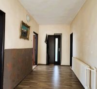 Chodba v rodinném domě s podlahou s dřevěným dekorem a obrazem na stěně.