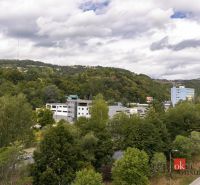 Výhled na zeleň a budovy v Banské Bystrici na Severní ulici, obklopené kopci.