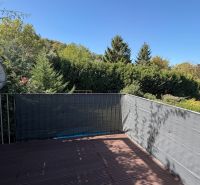 Balkon 3pokojového bytu ve Wolfsthale s výhledem na zeleň a satelitní anténou.