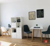 Interiér 1-pokojového bytu s podlahou s dřevěným dekorem a stylovými židlemi.