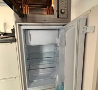 Kuchyňská linka s mikrovlnkou a otevřenou ledničkou. Podlaha s dřevěným dekorem.
