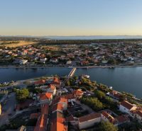Letecký pohled na město Nin s vilami podél pobřeží a panoramatem moře.