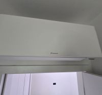 Klimatizace na stěně v interiéru vily s bílým designem a hladkým povrchem.
