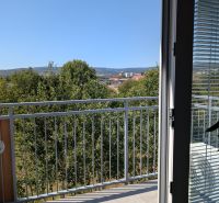 Výhled z 2pokojového bytu v Pezinku na ulici Mahulanka zahrnuje balkon a stromy.