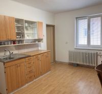 Kuchyně s dřevěnou linkou a podlahou s dřevěným dekorem v rodinném domě.