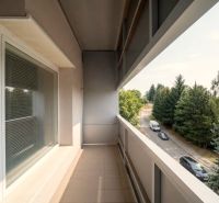 Balkon 2-pokojového bytu v Bánovcích nad Bebravou s výhledem na silnici a stromy.
