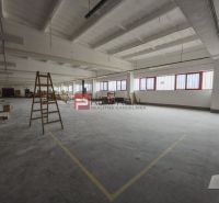 Prostor s betonovou podlahou a pracovním obsahem ve výrobních prostorách.