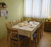 Jídelna v rodinném domě s prostřeným stolem a podlahou s dřevěným dekorem.