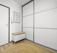 Vstupní hala v 2-pokojovém bytě s podlahou s dřevěným dekorem a minimalistickým nábytkem.
