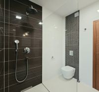Koupelna se sprchovým koutem a závěsným WC ve 4pokojovém bytě.